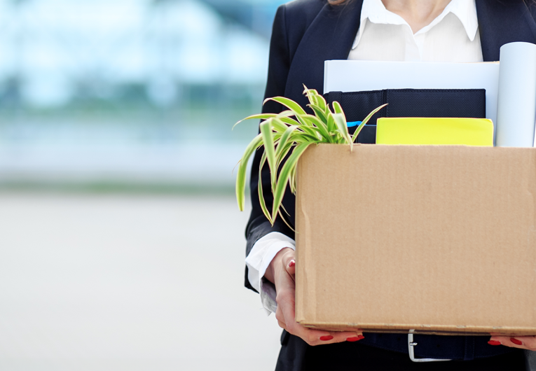 Woman leaving job with a box of personal items.