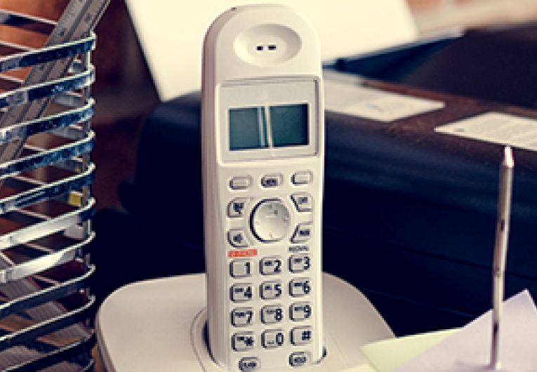 Image of a business landline phone in its cradle.
